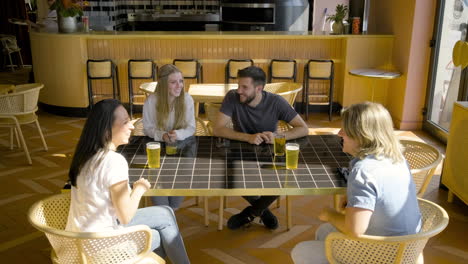 vista superior de un grupo de amigos sentados en una mesa de restaurante mientras hablan entre ellos