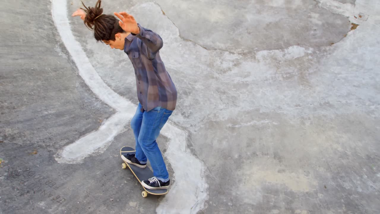vista de alto ángulo de un joven caucásico practicando patinaje en la rampa en el parque de patinaje 4k