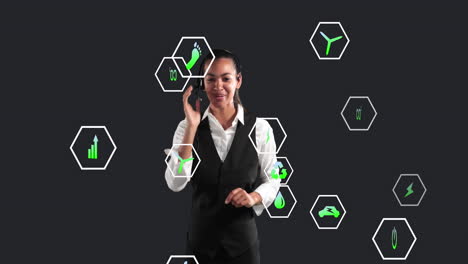 animación de múltiples iconos digitales sobre una mujer de negocios biracial hablando con auriculares telefónicos