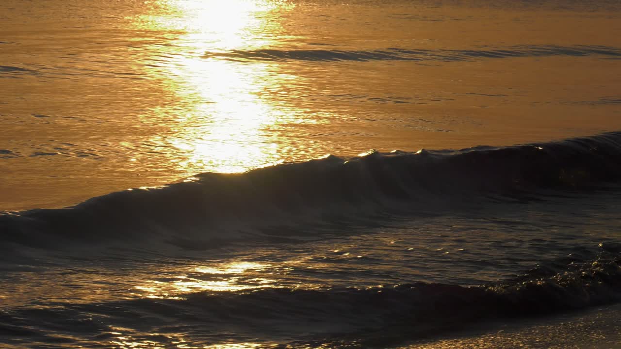 日の出に太陽を反射する黄金の海、海岸に打ち寄せる波、地中海、スペイン