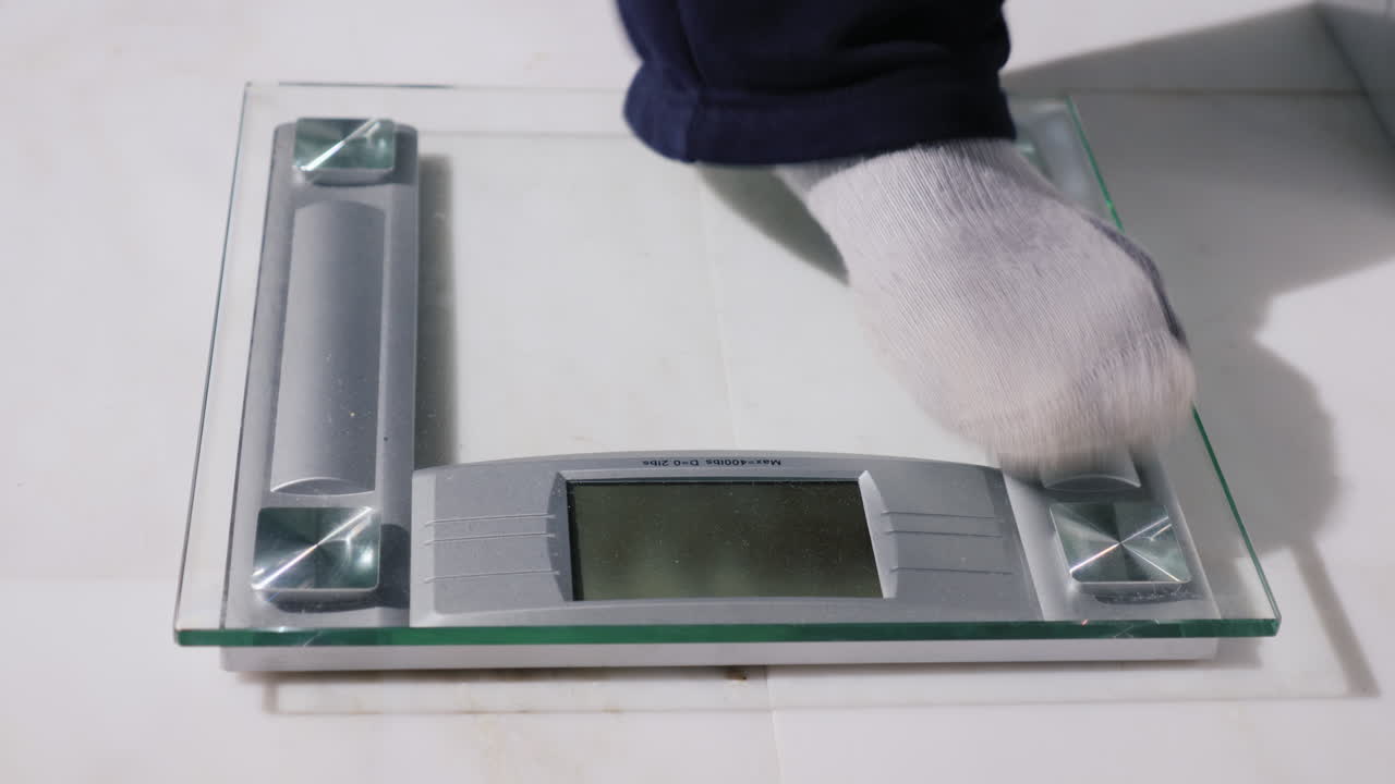 남자는 바닥 저울에 무게