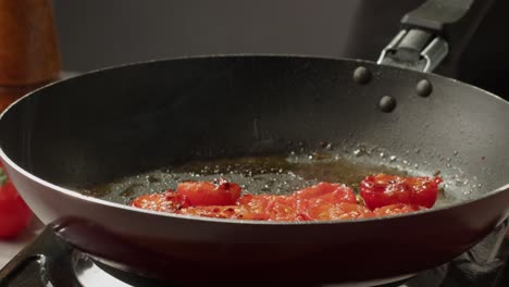 frying sliced tomatoes in a pan