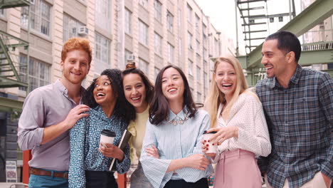 happy young work colleagues hang out outside their workplace