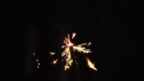 lit party sparkler sparkling on black background