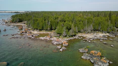 aerial ascent backup of wilderness forested coastline, les cheneaux islands, michigan