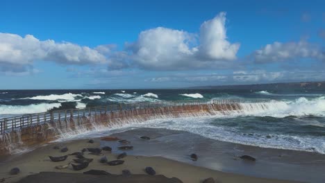 ocean waves crashing and smashing over la jolla childrens pool during king tide with ruff water