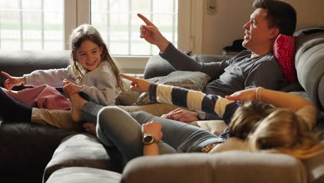 family relaxing and interacting on a couch