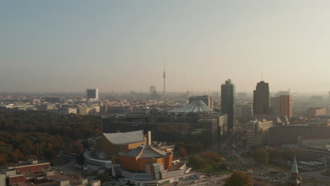 Luftpanoramablick-Auf-Die-Stadt,-Beleuchtet-Von-Heller-Morgensonne.-Vorwärts-Fliegen-über-Die-Berliner-Philharmonie.-Fernsehturm-Fernsehturm-In-Der-Ferne.-Berlin,-Deutschland