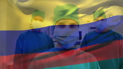 animation of waving colombia flag against portrait of team of diverse surgeons at hospital