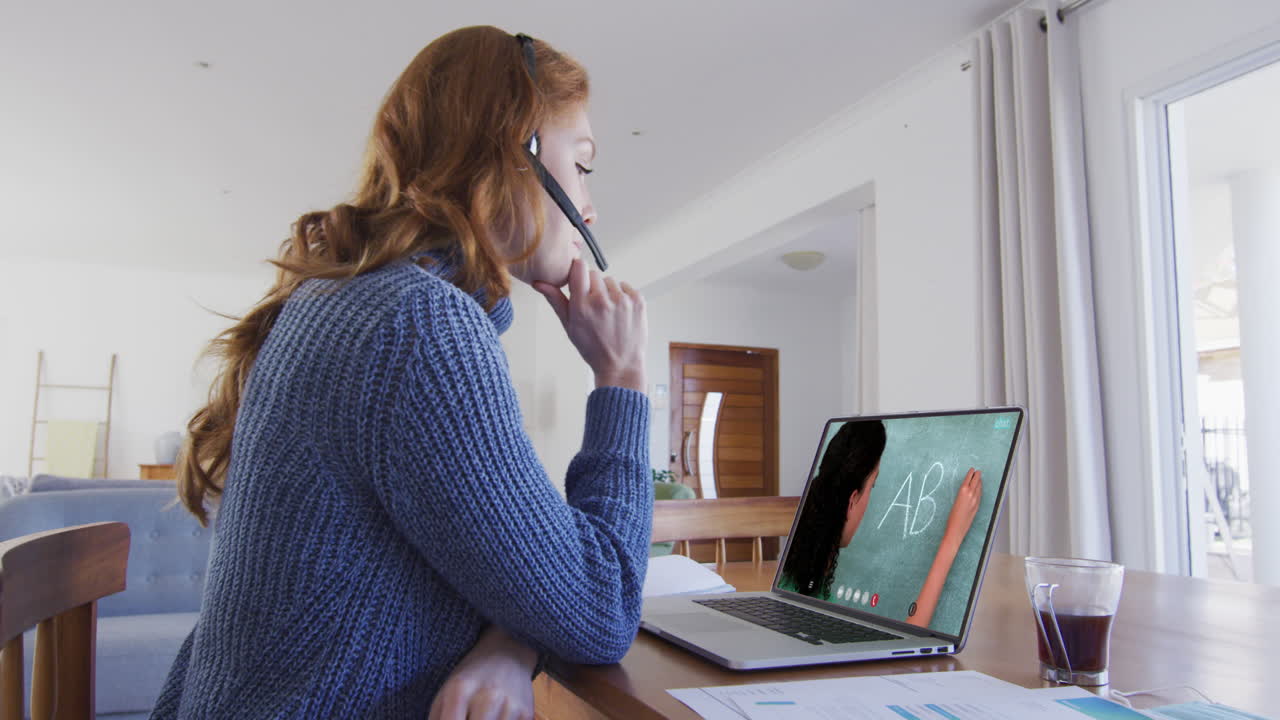 Kaukasisk kvindelig studerende bruger bærbar computer og headset på videoopkald med kvindelig lærer.