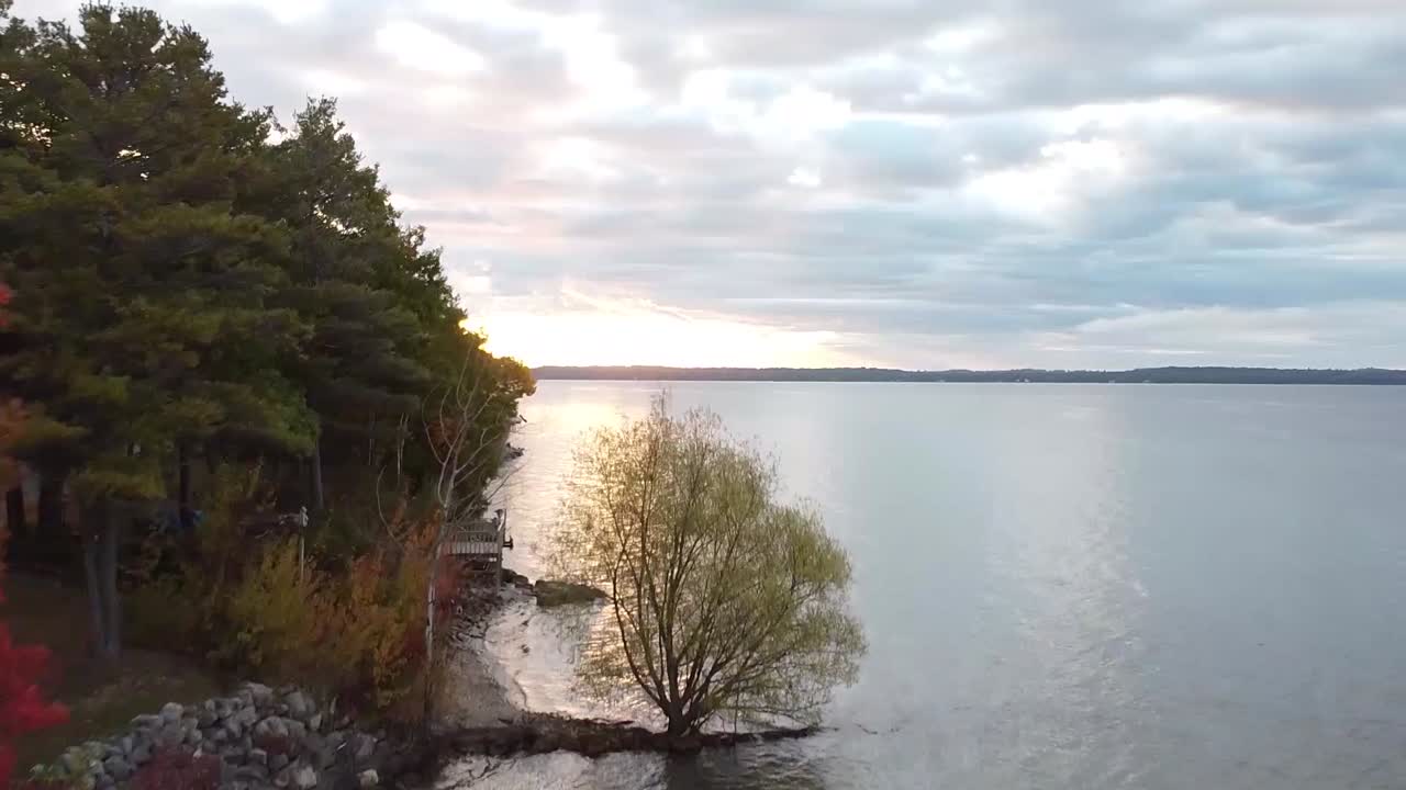 drone de otoño ascendente disparado sobre la costa del lago michigan al amanecer