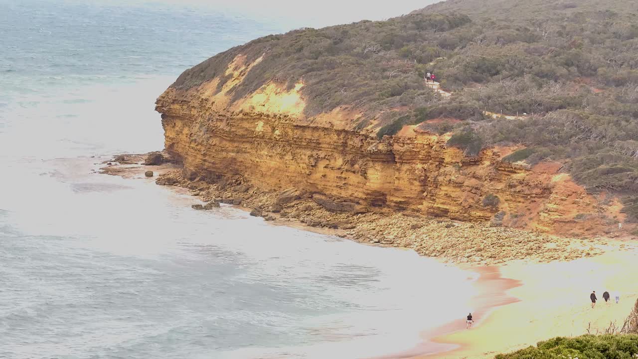 Aerial view of rugged cliffs and beach at Great Ocean Road, Australia. Soft lighting enhances the natural beauty and serene atmosphere