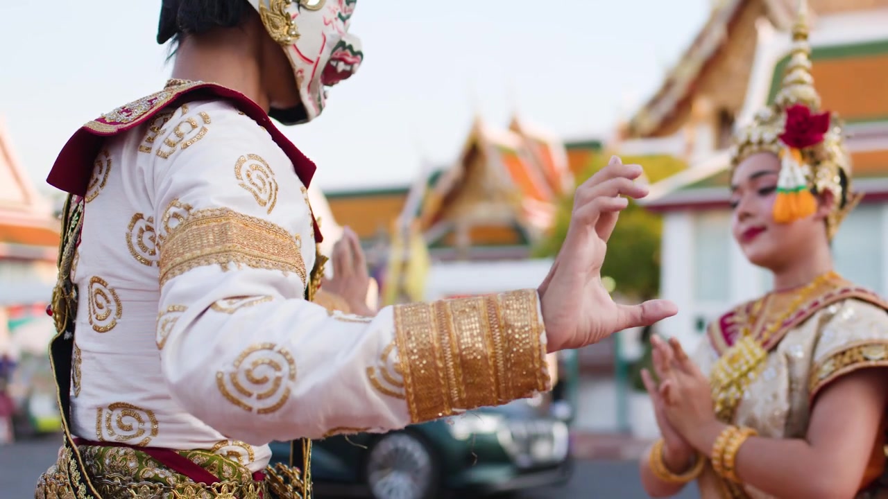 Penampil berkostum mewah menari di luar Wat Suthat Thepwararam selama pertunjukan teater Khon tradisional