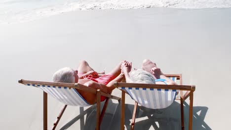 retired old couple lying on deckchair