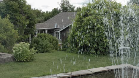 Walking-through-the-front-yard-of-a-beautiful-mansion-on-a-acreage-with-a-elegant-fountain-feature-and-beautiful-landscaping-with-bushes-all-around