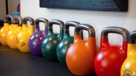 colorful gym weights on the floor of a gym