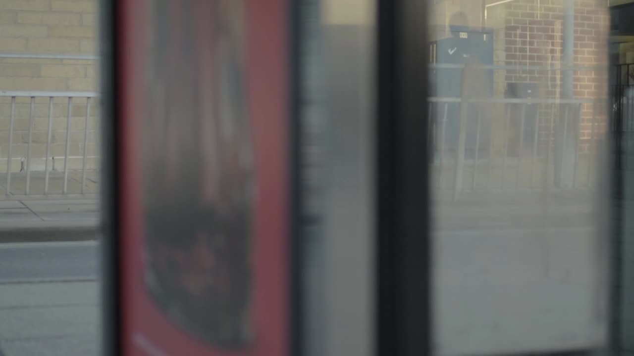 View of urban city traffic through phone box