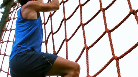 Man-climbing-the-net-during-obstacle-course