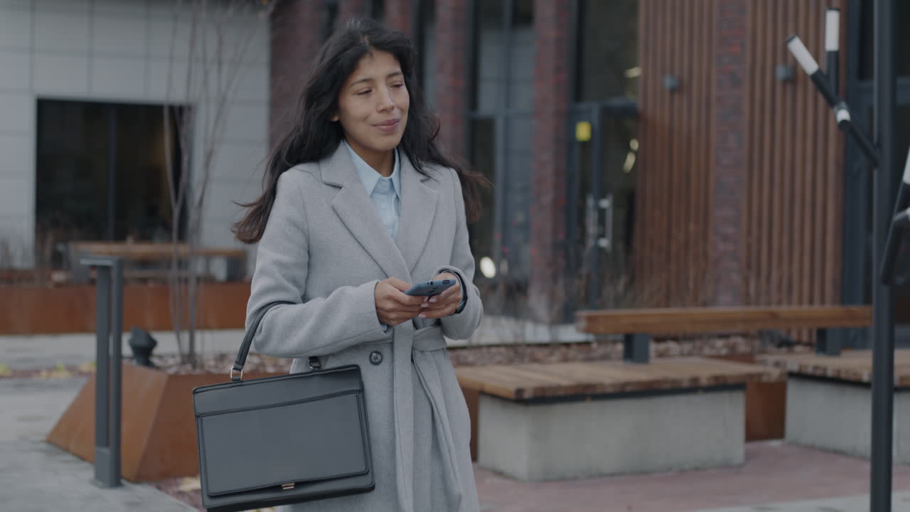Businesswoman Walking and Using Smartphone