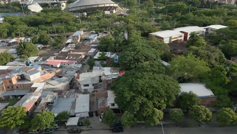 Cali-Colombia-Drone-Aerial-View-Cable-Cars-Moving-Over-Poor-Neighborhood-Homes-and-Trees-at-Sunset