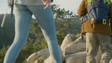 primer plano de una pareja joven caminando en la cima de la montaña