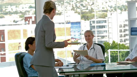 mujer de negocios recogiendo carpeta médica durante una reunión médica