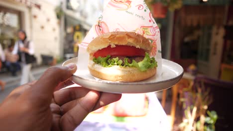 a person holding a delicious hamburger