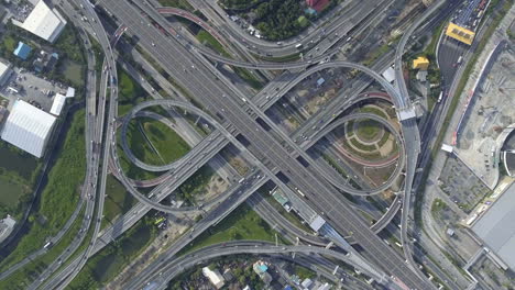 aerial view of highway road interchange with busy urban traffic speeding on road