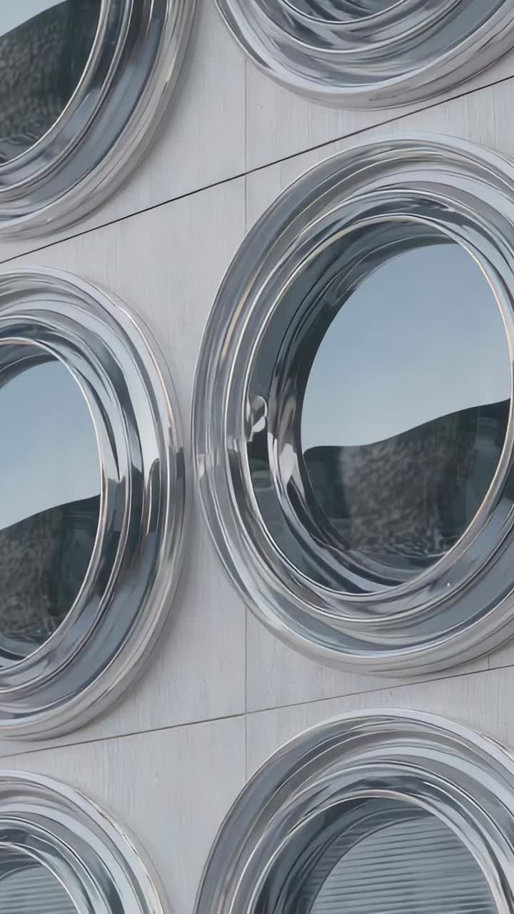 Vertical video: Panning camera revealing porthole windows on panels to show sliding sky reflections