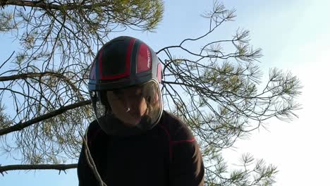 lower angle of a 30 years old woman wearing a helmet with a transparent visor, special for chainsawing