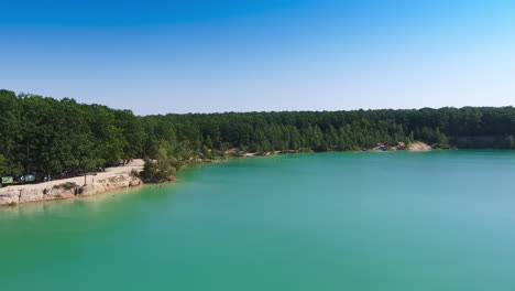 stunning scenery of a lake made by people. blue manmade pond at the place of former quarry and bank overgrown with trees.