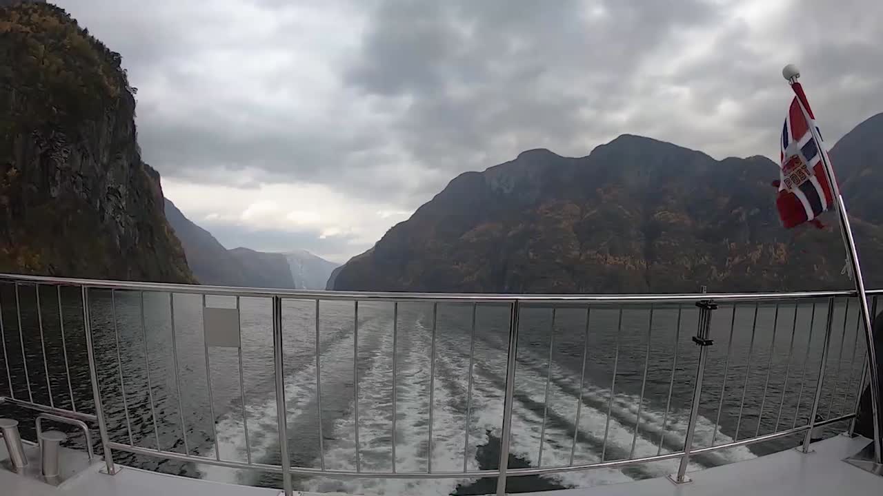 timelapse vista trasera del barco con bandera noruega navegando a través de los fiordos noruegos