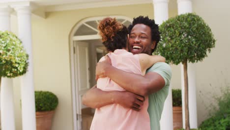 Feliz-Pareja-Birracial-Abrazándose-Con-Alegría-Frente-A-La-Nueva-Casa