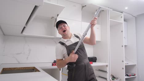 a very fun craftsman during the repair simulating playing the guitar using the tools a very fun craftsman during the repair simulating playing the guitar using the tools the furniture assembler is having fun