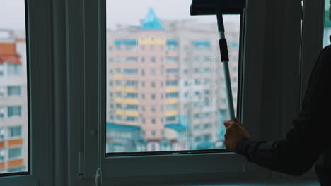 window cleaning with water and devices. glass cleaner working with wet windows.