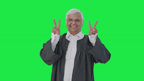 Happy-Indian-senior-lawyer-showing-victory-sign-Green-screen