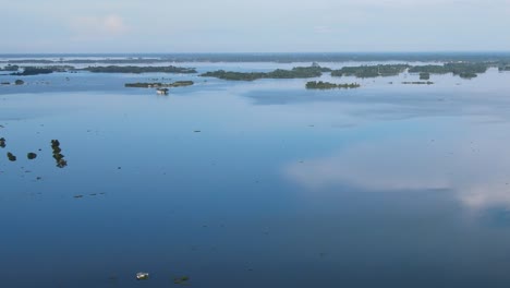 Aerial-Tilt-Up-View-Of-Calm-Reflective-Floodwaters-In-Sylhet,-Bangladesh