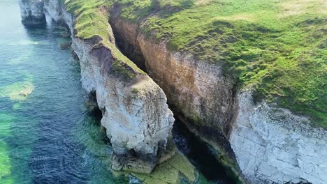 beautiful chalk coastal cliffs at low tide, with visible cracks showing in the cliff faces