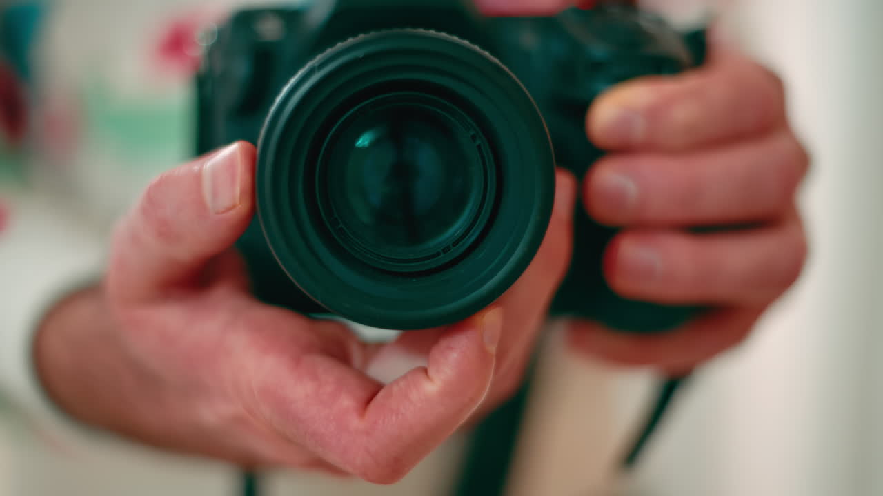 Man holding a camera shooting in the mirror. Rotating focus ring