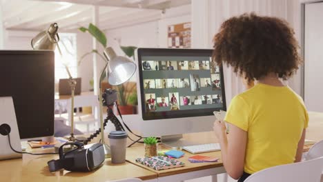 mixed race woman working on computer in creative office