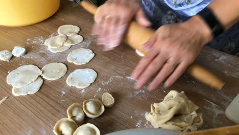 the woman rolls out the dough with rolling pin