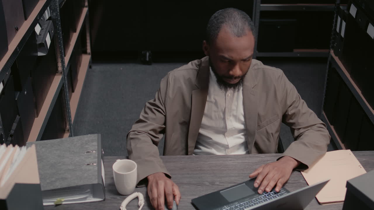 Man working at desk with laptop and coffee