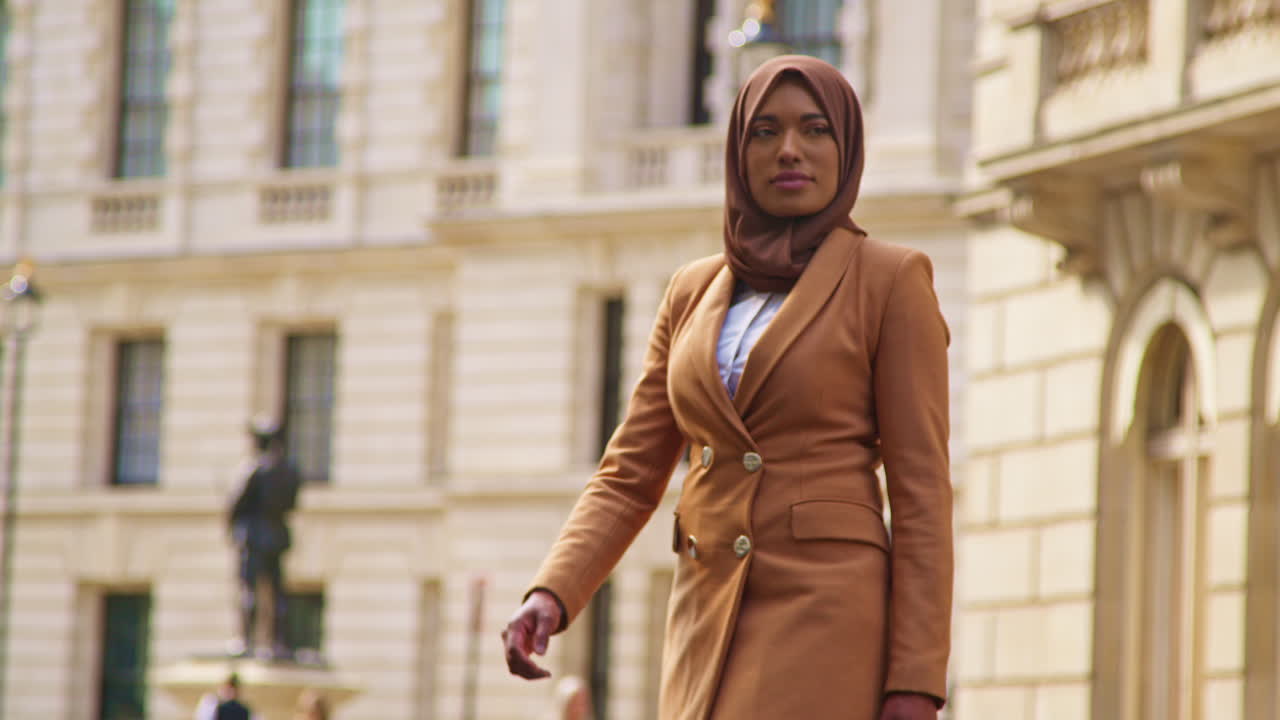 Muslim Businesswoman Wearing Hijab With Modern Business Suit Walking To Work Past City Office Buildings 2