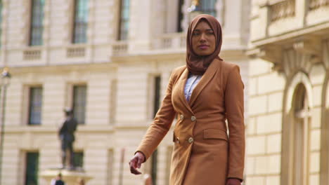 Muslim-Businesswoman-Wearing-Hijab-With-Modern-Business-Suit-Walking-To-Work-Past-City-Office-Buildings-2