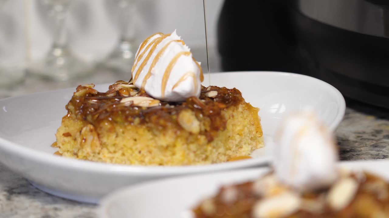 jarabe de caramelo rociado o vertido sobre un trozo de pastel de plátano y caramelo cubierto con glaseado