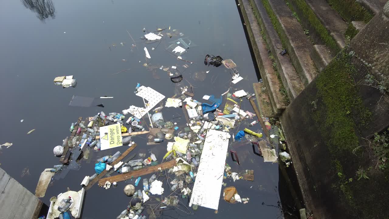 Rubbish floating in disused dock Woolwich London UK