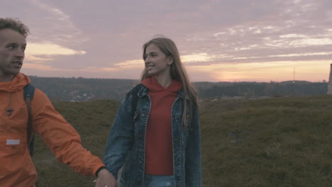 pareja joven de excursionistas masculinos y femeninos en la cima de la montaña