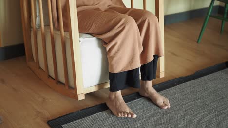 mujer sentada en una silla de balanceo de madera