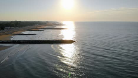 scenic aerial drone fly over shot above calm sea waves and jettys, sunset, calm scene, nobody, seascape, lifestyleaeri