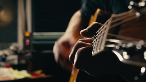 joven músico comprobando las cuerdas de una guitarra acústica de cerca. guitarrista masculino afinando el sonido de un instrumento musical.